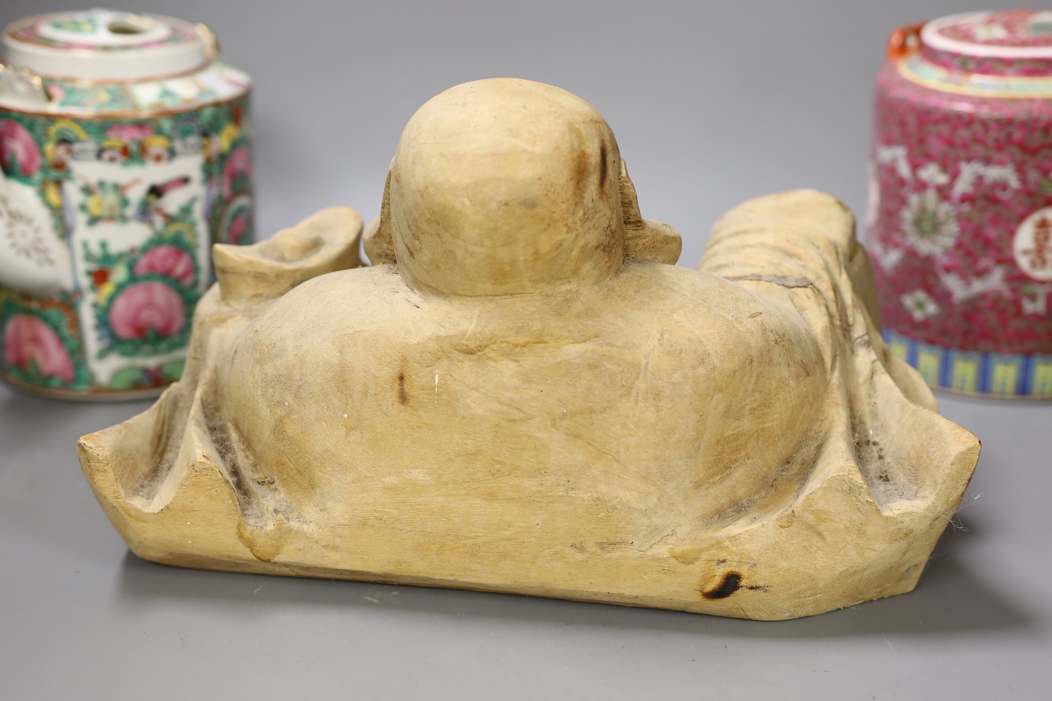 A Chinese wooden figure of Budai, two teapots in baskets and a tea caddy